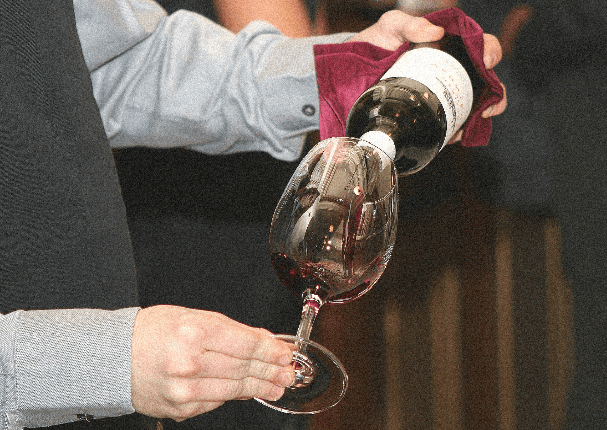 sommelier versant du vin rouge dans un verre